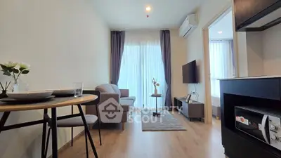 Modern living room with cozy seating and natural light in a stylish apartment.
