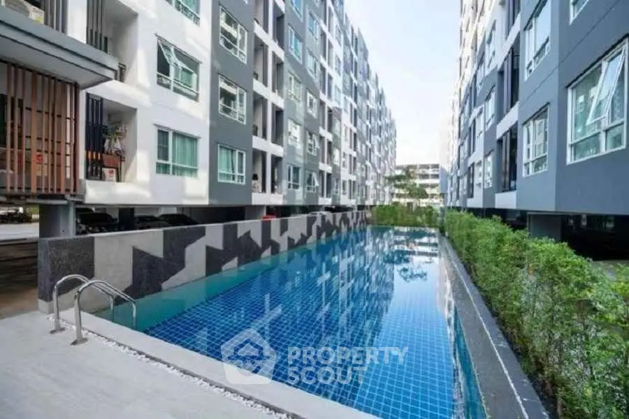 Modern apartment complex with sleek pool and contemporary architecture.