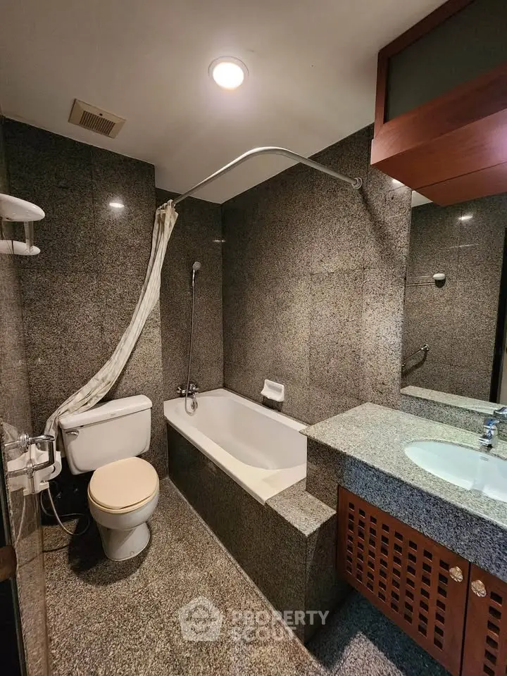 Luxurious granite bathroom with bathtub and modern fixtures in upscale property.