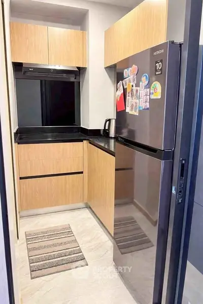 Modern compact kitchen with sleek appliances and wooden cabinetry