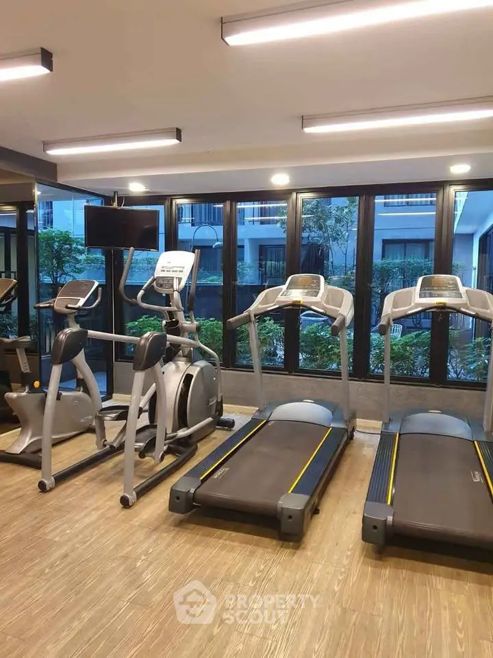 Modern gym with treadmills and exercise bikes in a residential building