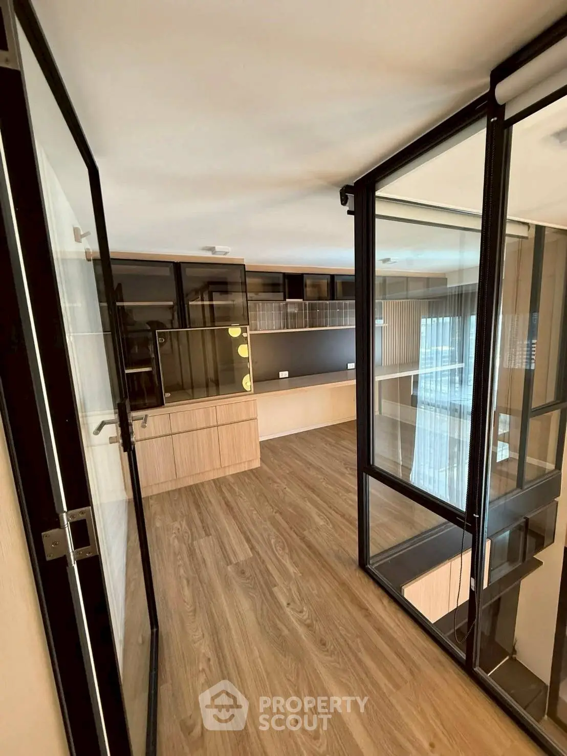 Modern study room with glass partitions and wooden flooring