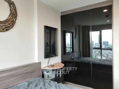 Modern bedroom with large mirrored wardrobe and city view window, perfect for urban living.