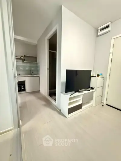 Modern compact apartment with sleek kitchen and cozy living area, perfect for urban living.