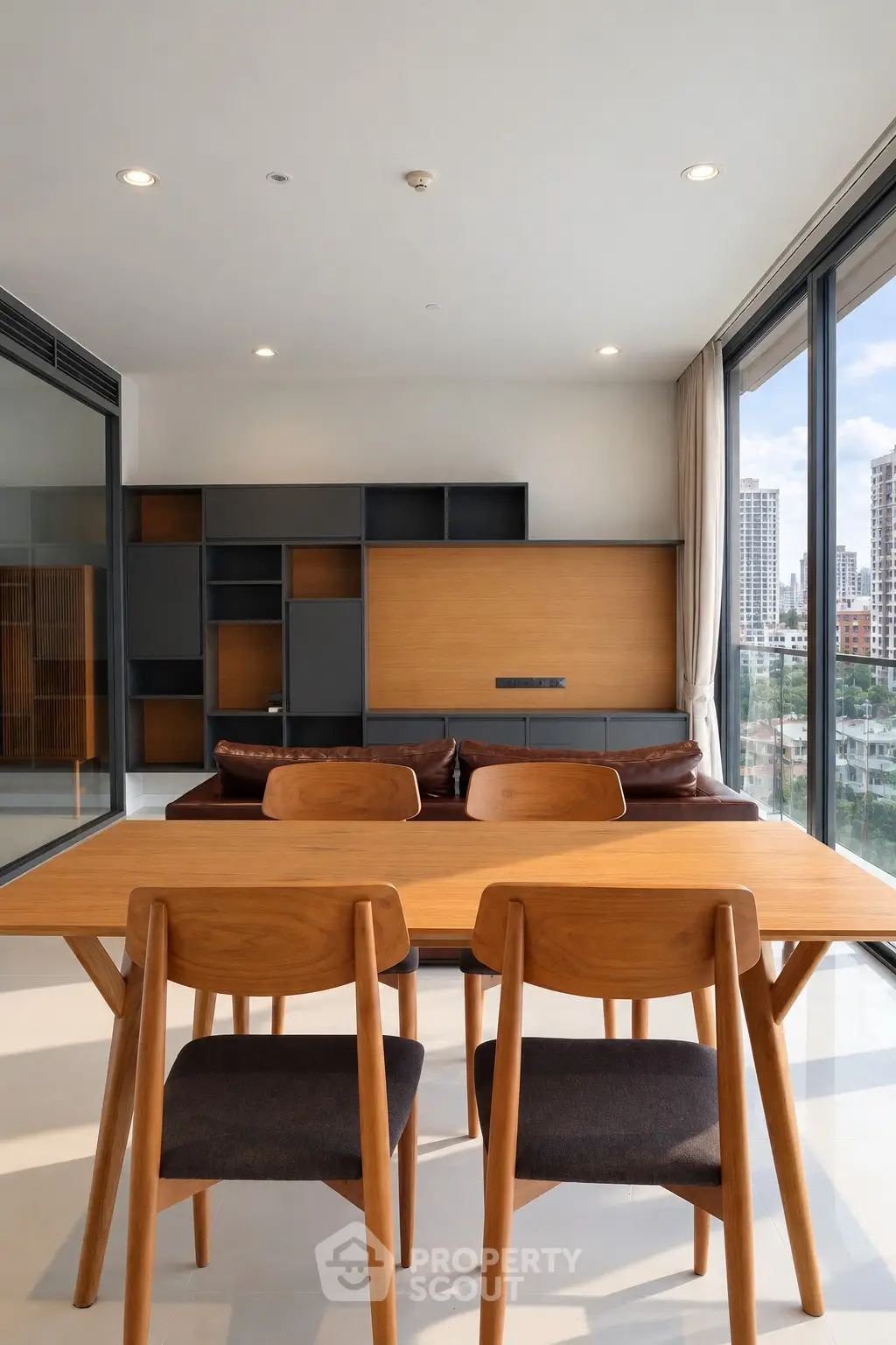 Modern living room with stylish wooden furniture and large windows offering city views.