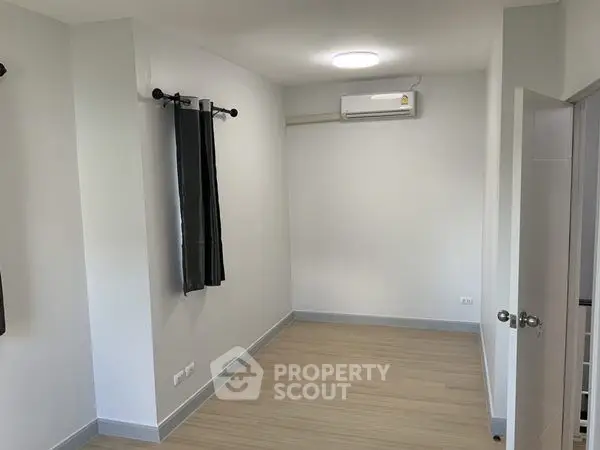 Spacious empty room with air conditioning and wooden flooring