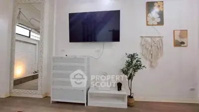 Stylish living room with modern decor, wall-mounted TV, and elegant mirror