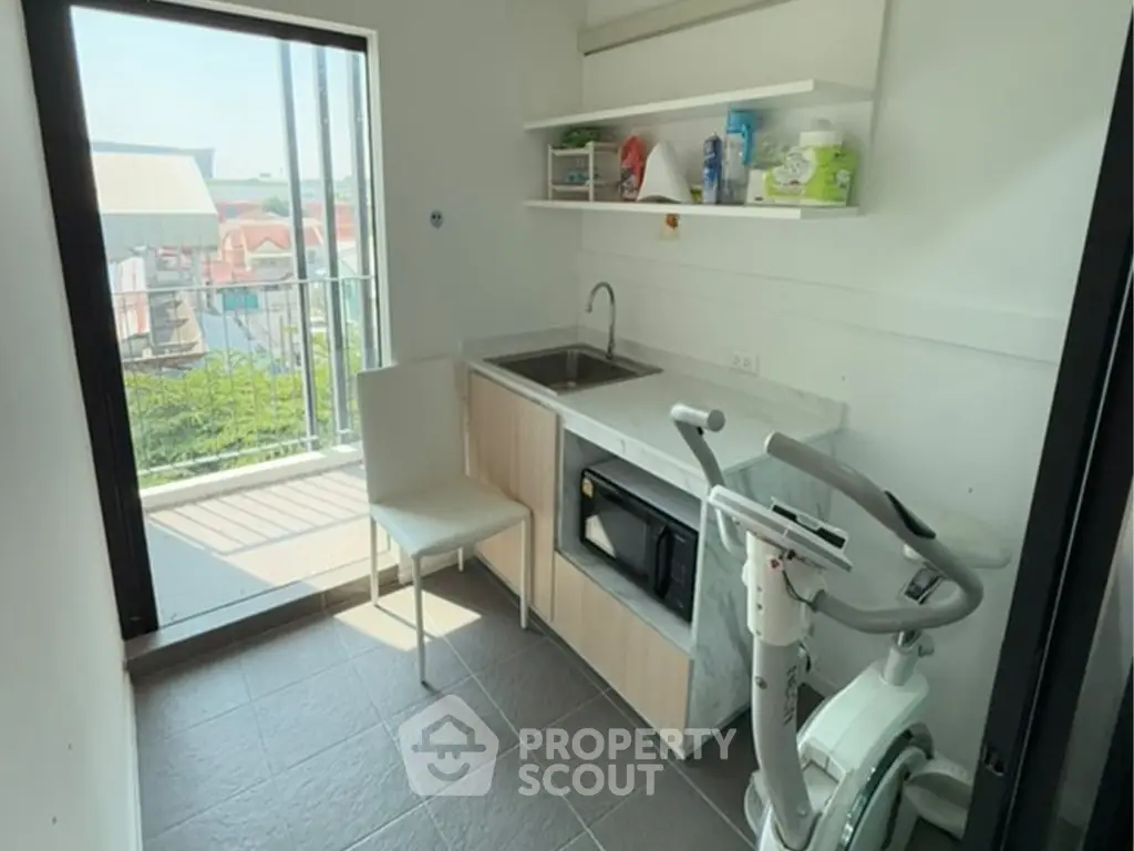 Compact utility room with balcony access and exercise equipment