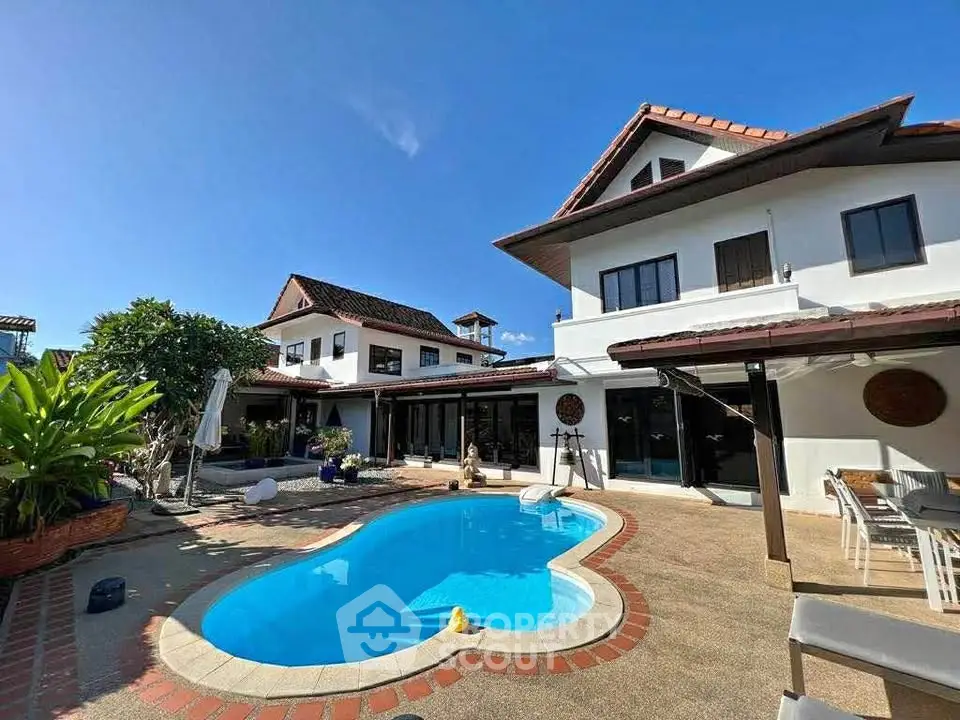 Stunning villa with private pool and spacious outdoor area under clear blue sky.