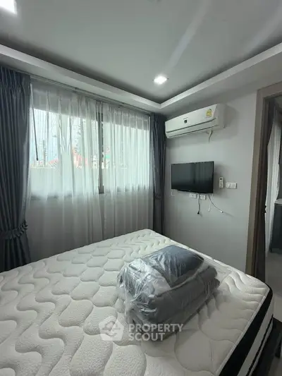 Modern bedroom with large window, air conditioning, and wall-mounted TV in a stylish apartment.