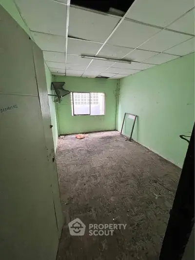 Spacious room with potential for renovation, featuring natural light and a simple layout.