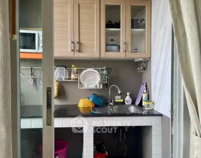Compact kitchen with modern cabinetry and essential appliances, perfect for efficient cooking in small spaces.