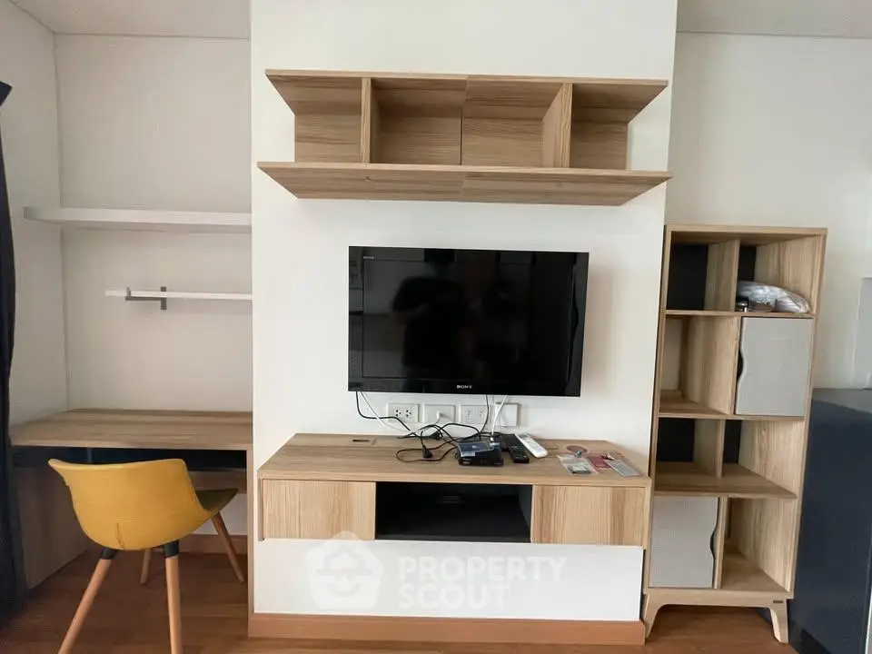 Modern living room with stylish wooden furniture and mounted TV, perfect for cozy urban living.