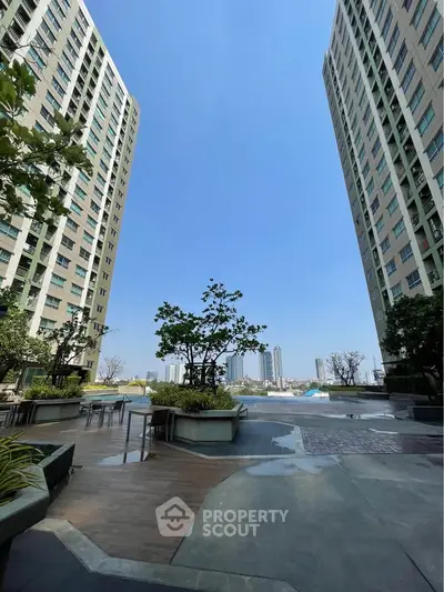 Stunning view of modern high-rise buildings with lush greenery and open sky, perfect for urban living.