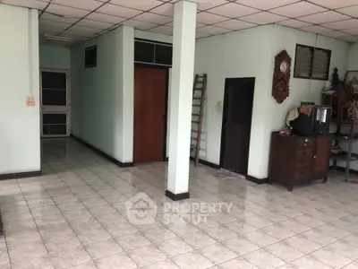 Spacious interior with tiled flooring and vintage decor, ideal for creative renovation.