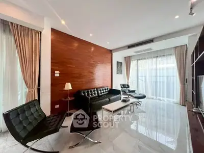 Modern living room with sleek furniture and large windows for natural light.