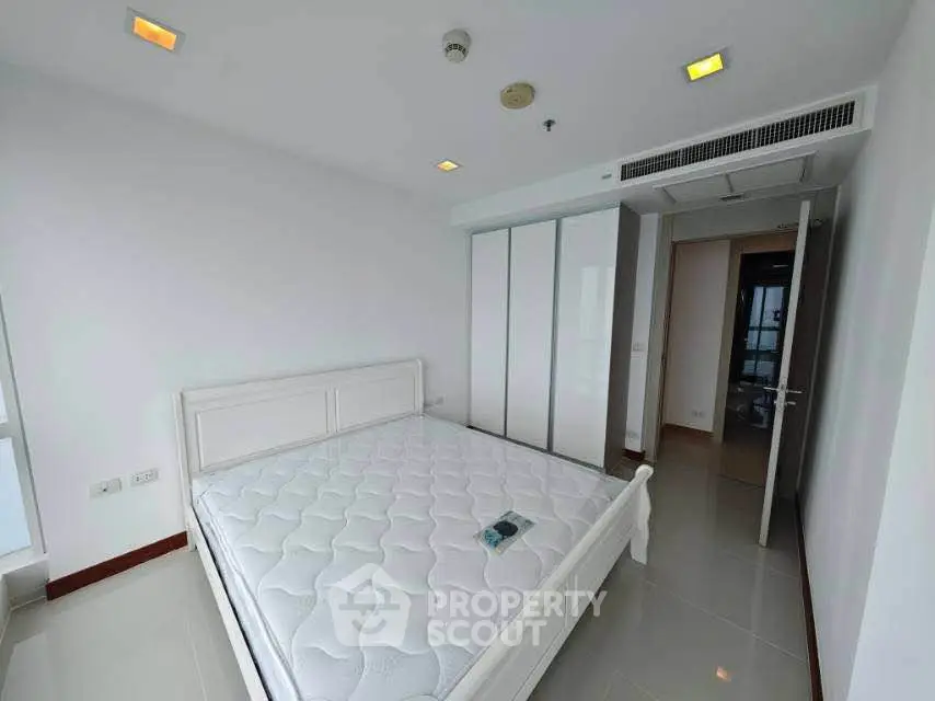 Spacious bedroom with modern white decor and large wardrobe