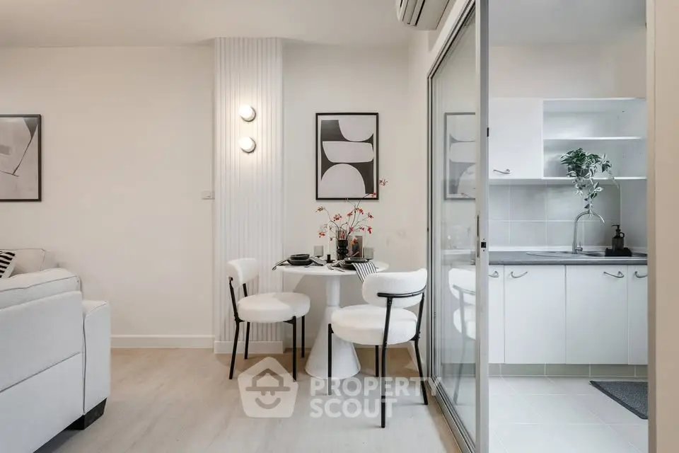 Modern open-plan living and dining area with stylish decor and sliding glass doors to a sleek kitchen.