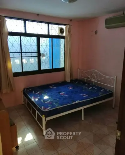 Cozy bedroom with natural light and simple furnishings, ideal for a peaceful retreat.