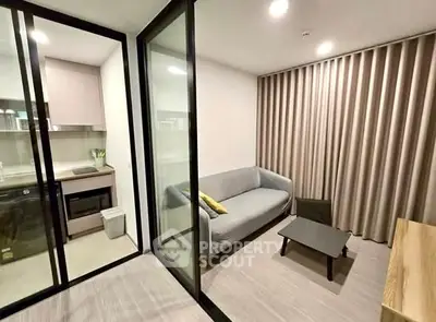 Modern living room with glass partition and compact kitchen area