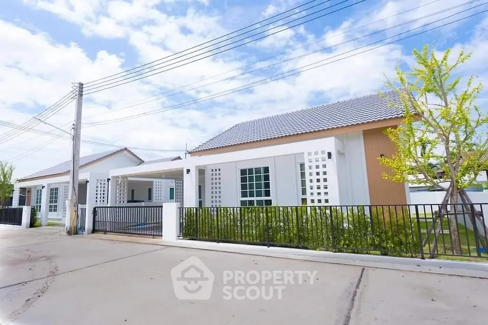 Modern single-story house with sleek design and spacious driveway.