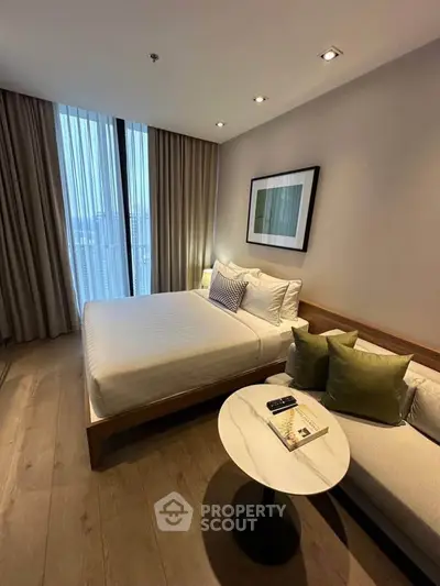Modern bedroom with cozy bed, stylish sofa, and elegant decor in a high-rise apartment.