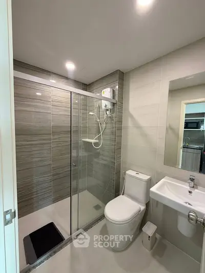 Modern bathroom with glass shower and sleek fixtures in a contemporary apartment.