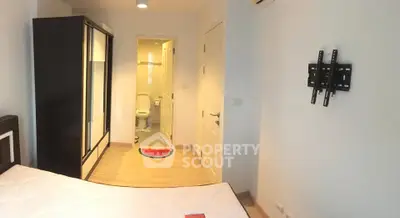 Modern bedroom with ensuite bathroom and wall-mounted TV bracket, featuring sleek wardrobe and minimalist design.