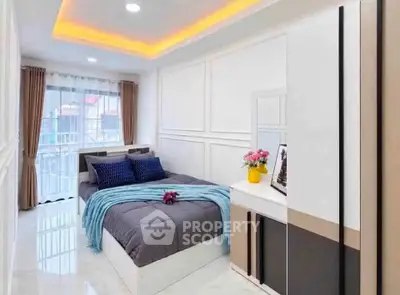 Modern bedroom with stylish decor and large window offering natural light
