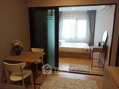 Modern apartment with cozy bedroom and stylish dining area, featuring wooden flooring and elegant decor.