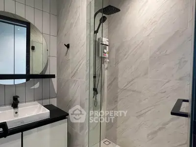 Modern bathroom with sleek shower and stylish vanity in contemporary apartment.