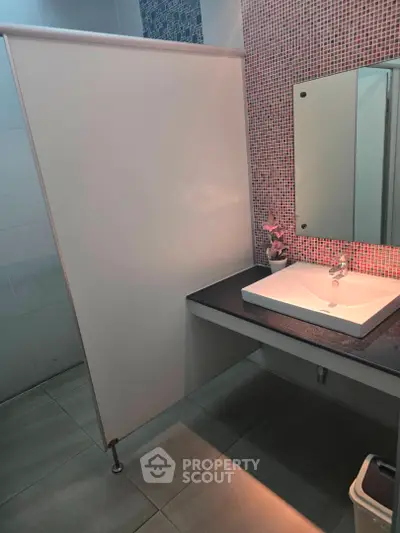 Modern bathroom with stylish sink and mosaic tile accent wall
