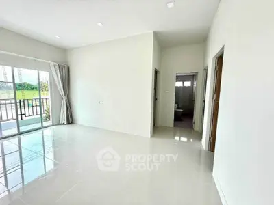 Spacious modern living room with large windows and glossy white tiles