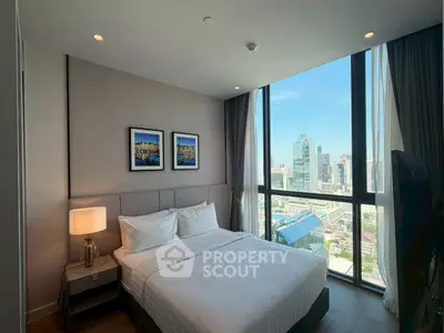 Luxurious bedroom with stunning city view and modern decor in high-rise apartment.