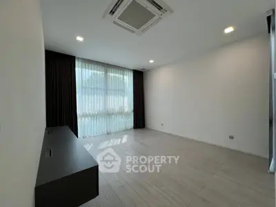 Spacious empty room with large window and modern ceiling air conditioning