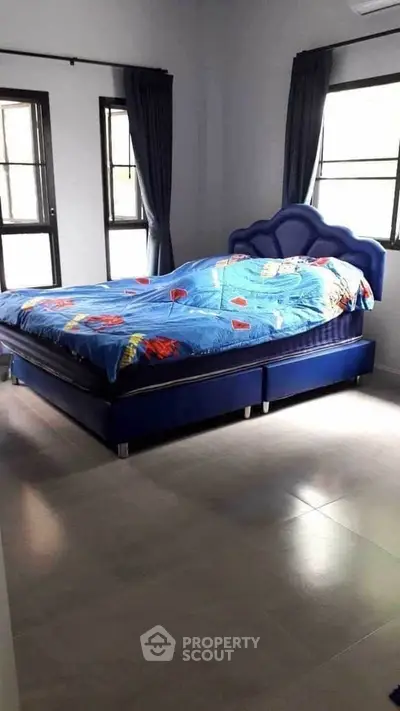 Cozy bedroom with blue bed and natural light from windows