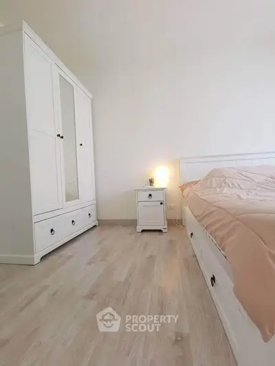 Spacious bedroom with elegant white furniture and cozy lighting, perfect for relaxation.
