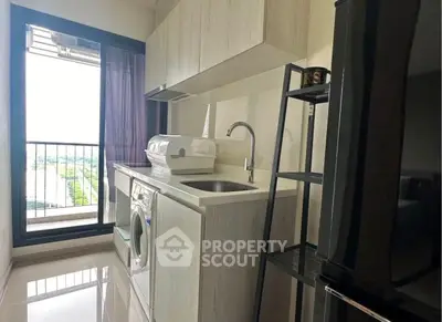 Modern kitchen with washing machine and balcony view in high-rise apartment