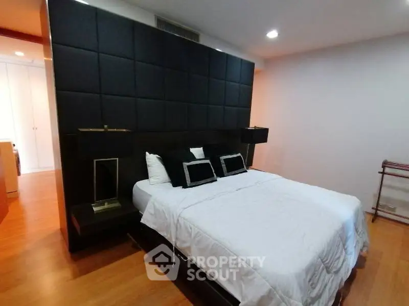 Luxurious bedroom with modern design and elegant black headboard in a stylish apartment.