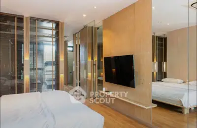 Luxurious modern bedroom with sleek design and wall-mounted TV, featuring warm wooden accents and ambient lighting.