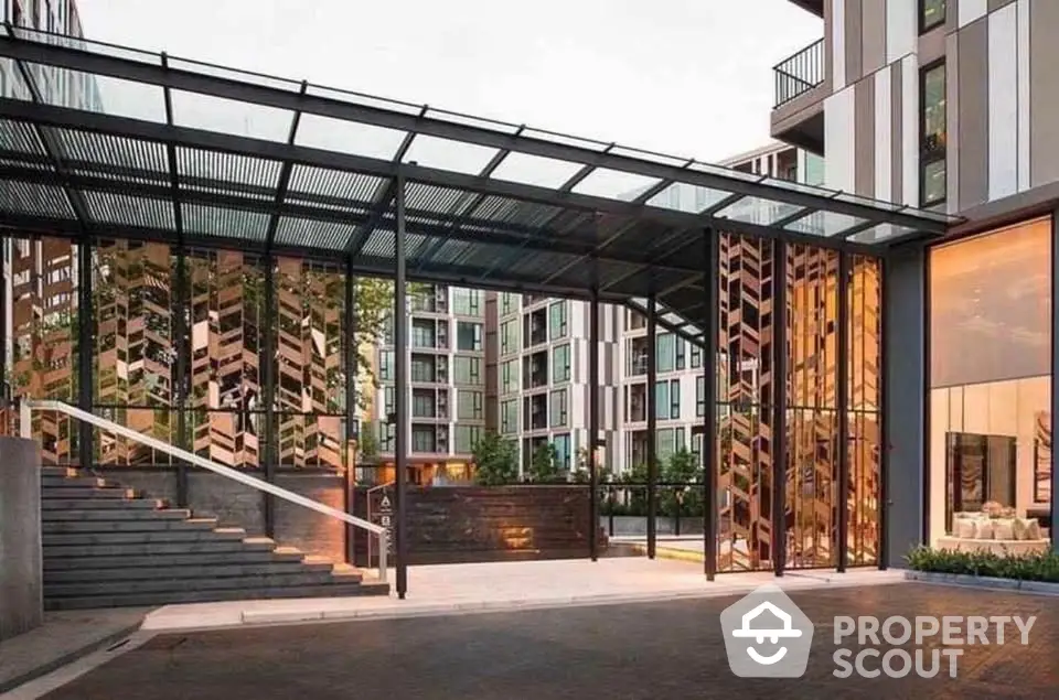 Modern apartment building entrance with glass canopy and stylish design