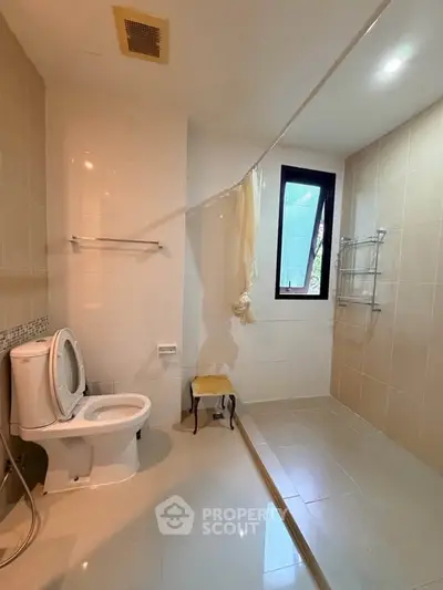Spacious modern bathroom with large window and sleek tile design