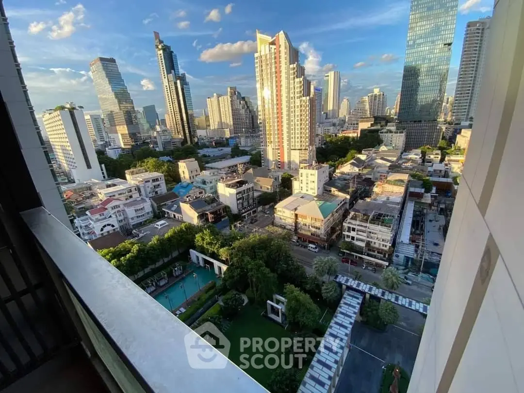 Stunning cityscape view from a high-rise balcony overlooking urban skyline and lush green spaces.