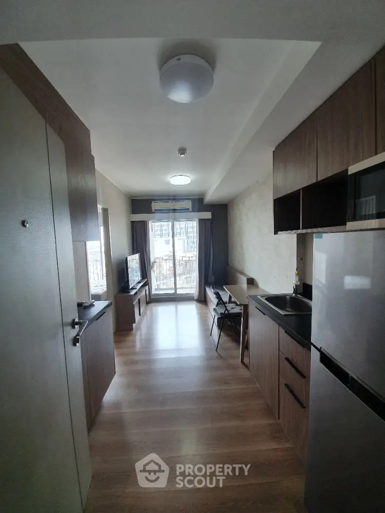 Modern studio apartment with open kitchen and balcony view