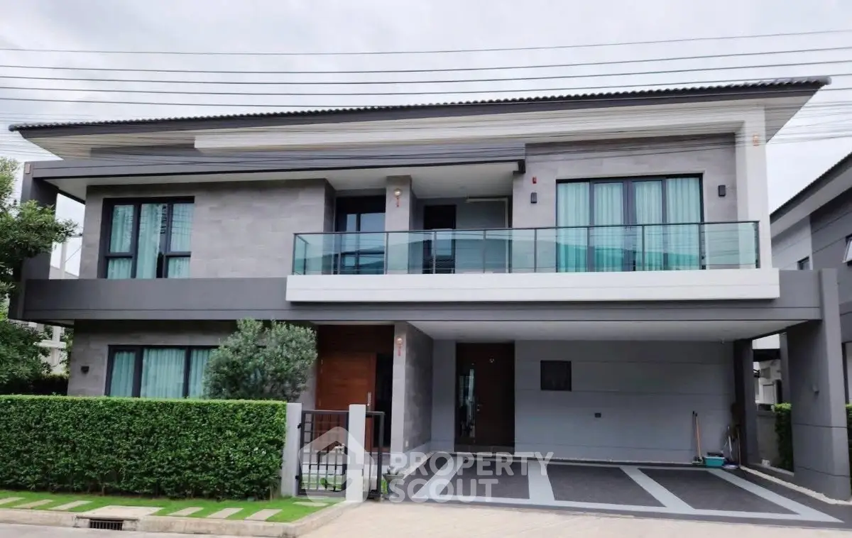 Modern two-story house with sleek design and spacious balcony in a serene neighborhood.