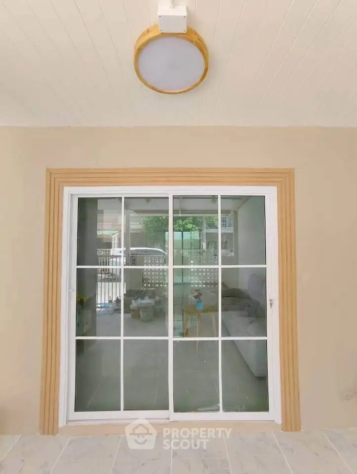 Modern sliding glass door with elegant frame leading to a cozy living room, enhancing natural light and space.
