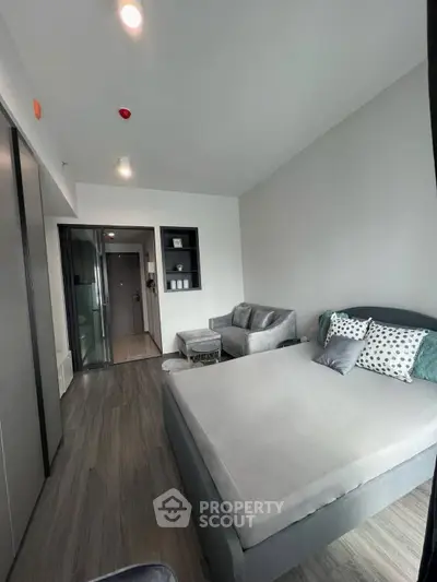 Modern bedroom with stylish decor and cozy seating area in a contemporary apartment.