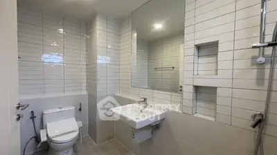 Modern bathroom with sleek white tiles and contemporary fixtures.