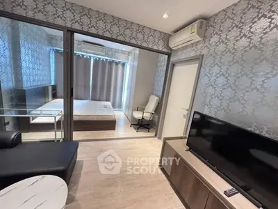 Modern living room with stylish decor and view into a cozy bedroom