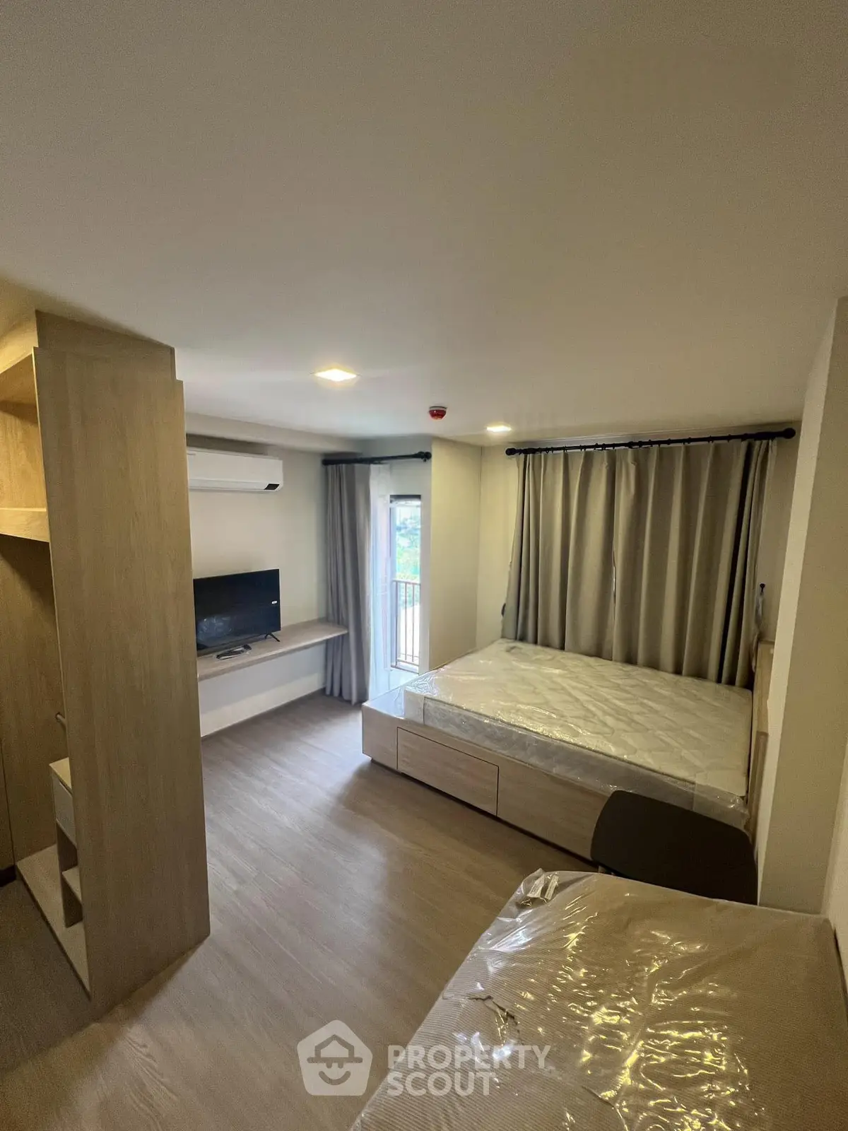 Modern bedroom with balcony access and sleek furnishings in a cozy apartment.